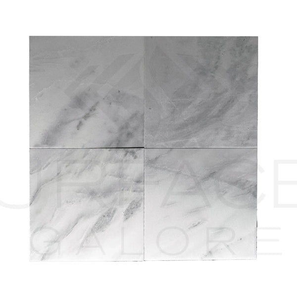 Four square Bianco Venatino White Marble tiles on a polished surface for flooring