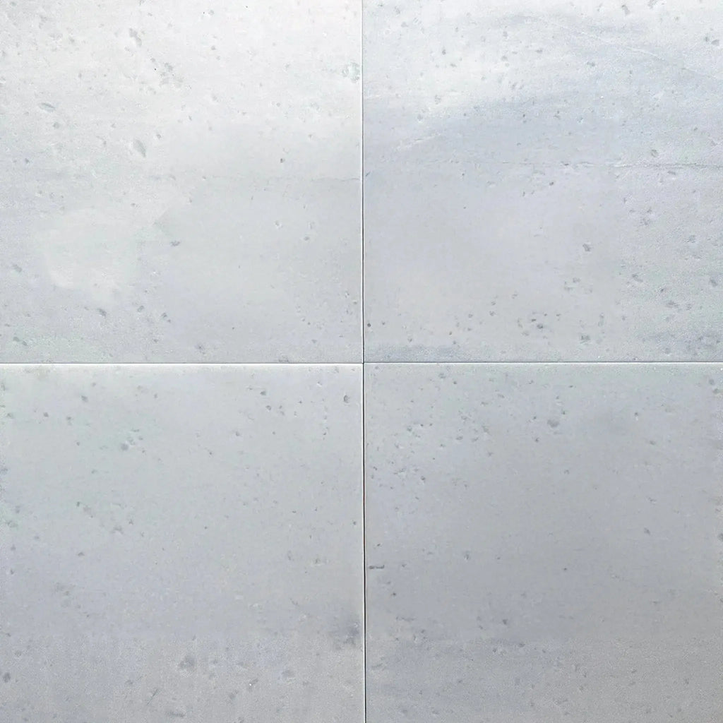 Four polished Aegean White Marble tiles displayed in a product listing