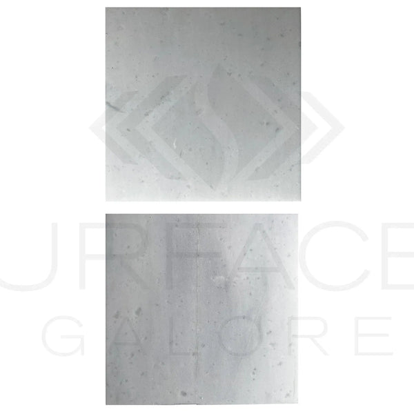 Two square light-colored Agean White Marble tiles, polished and 12X12 inches