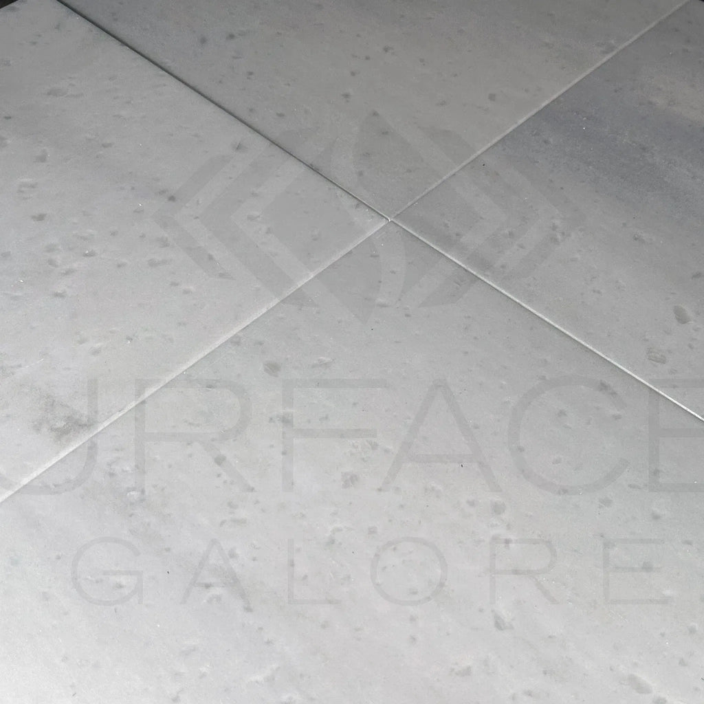 White speckled Agean White Marble 12X12 Polished Tile in a stylish flooring display