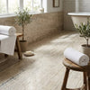 White waffle-weave bath towel rolled neatly on rustic wooden stool near alabastrino rustic white vein-cut travertine 12x24 tile