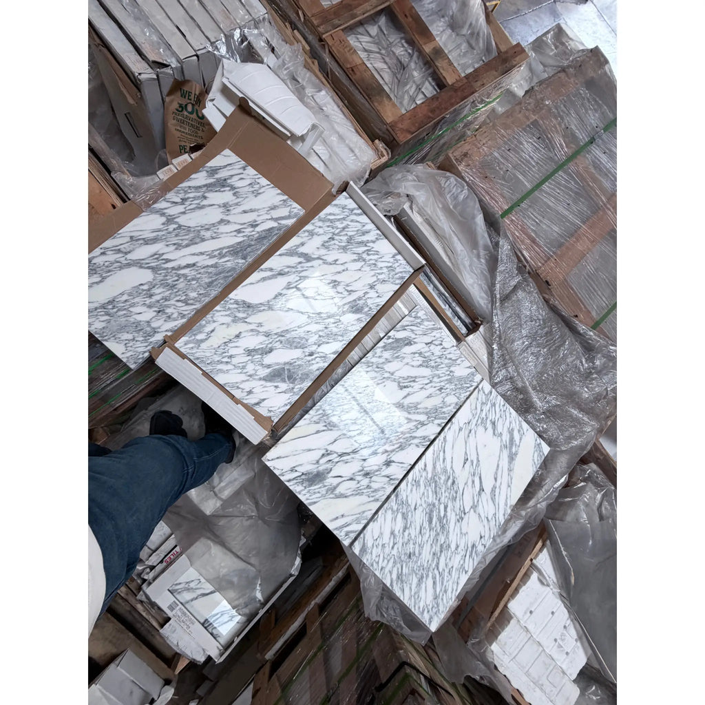White Arabescato Corchia marble slabs with gray veining on pallets