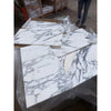 White marble arabescato corchia 12x24 tile slabs with intricate gray veining wrapped in clear plastic packaging