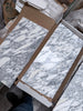 White and gray Arabescato Corchia marble tile in 12x24 polished slabs with natural veining, in open boxes