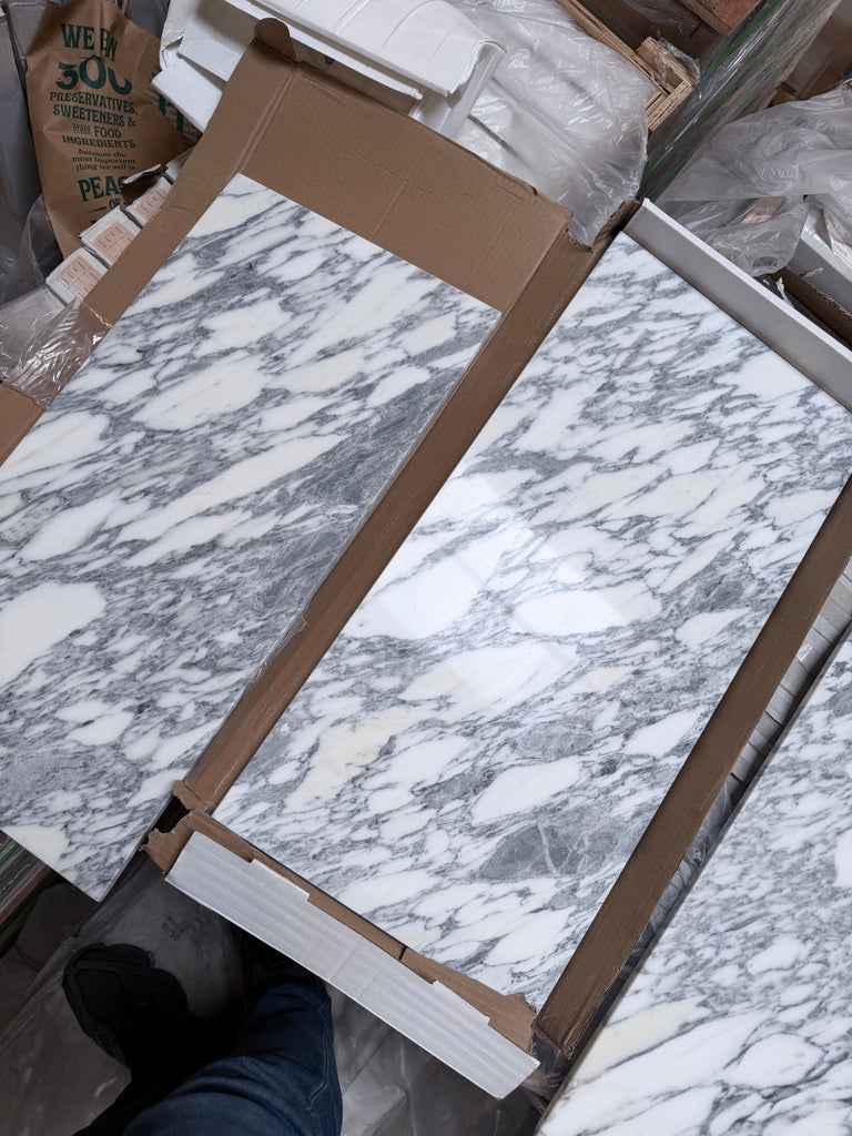 White and gray Arabescato Corchia marble tile in 12x24 polished slabs with natural veining, in open boxes