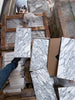 Stacked white and gray veined Arabescato Corchia marble slabs on pallets