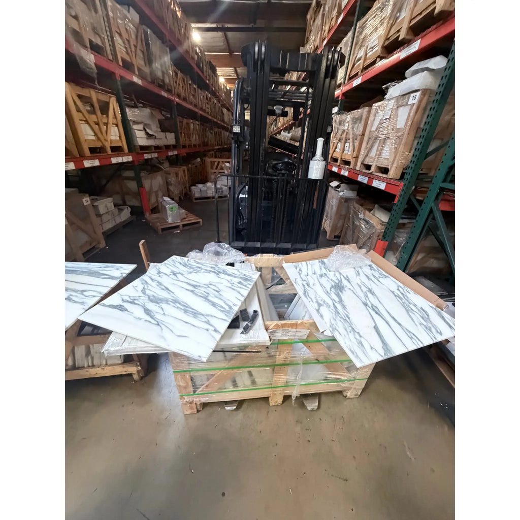 Black forklift with white stripes and red accents on Arabescato Corchia marble tile