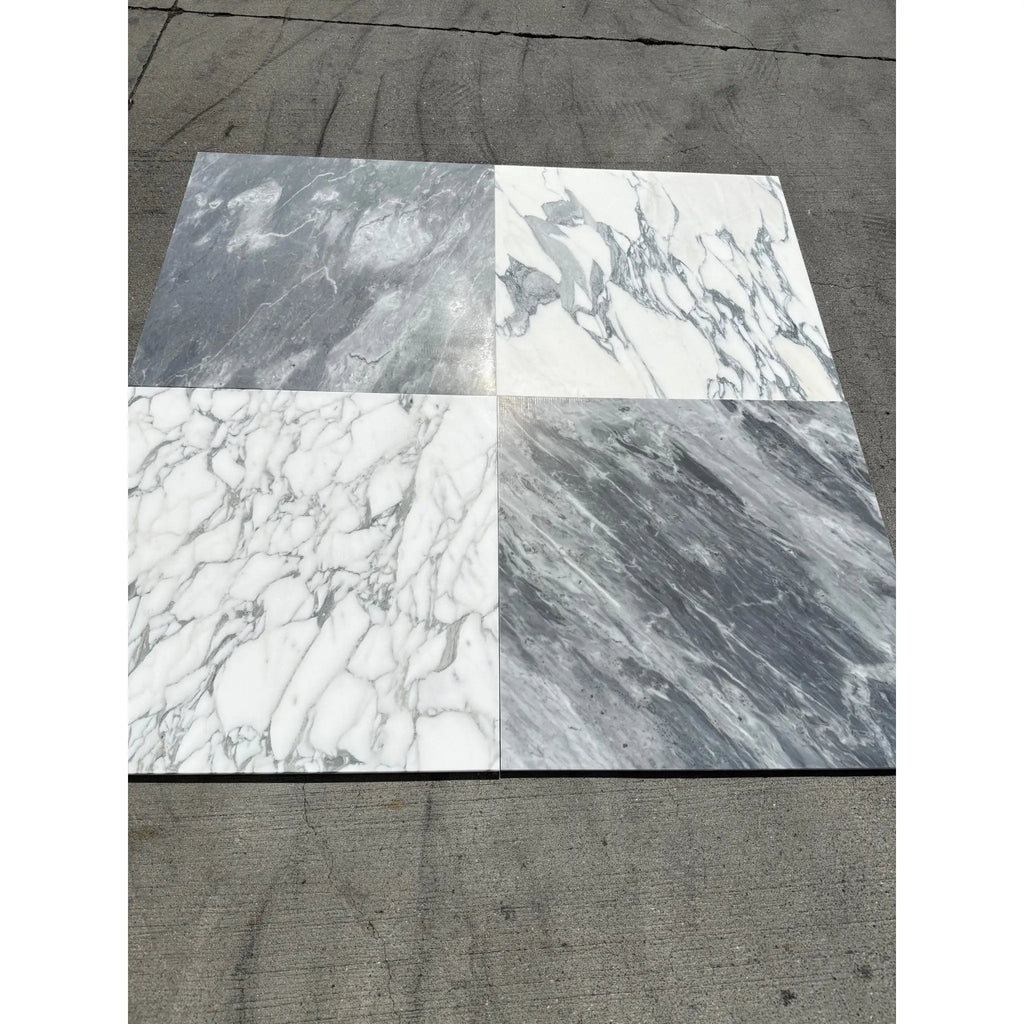 Four marble-like square tiles featuring Arabescato Corchia patterns in white and gray finishes