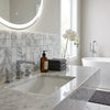 A sleek modern bathroom sink with white marble arabescato corchia 2x2 polished or honed countertop and integrated basin