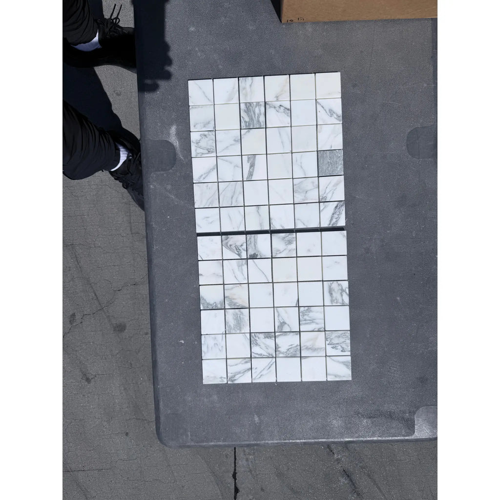 Two sheets of Arabescato Corchia 2x2 marble mosaic tiles in white and grey