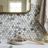 A rectangular lavender-scented soap with purple flecks in a rustic ceramic dish beside a wooden toothbrush
