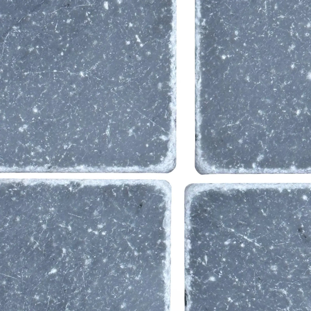 Four dark grey Bardiglio 3x3 Tumbled square tiles with visible white grout lines