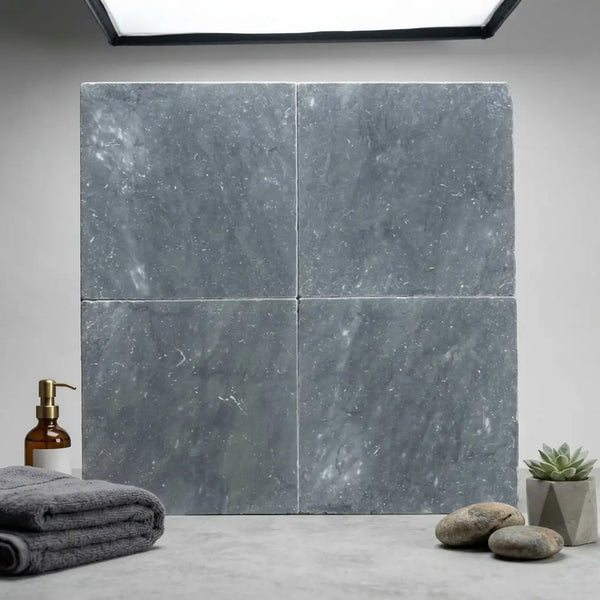 Four square gray bardiglio imperiale 12x12 marble tumbled tiles with subtle marbled texture arranged in a grid