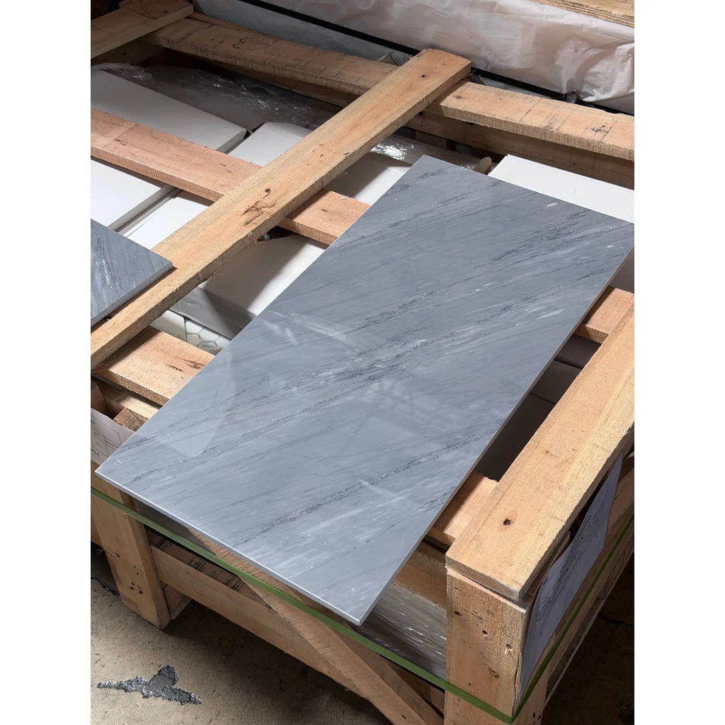 Bardiglio imperiale 12x24 polished or honed gray marble tile with subtle veining resting on a wooden pallet