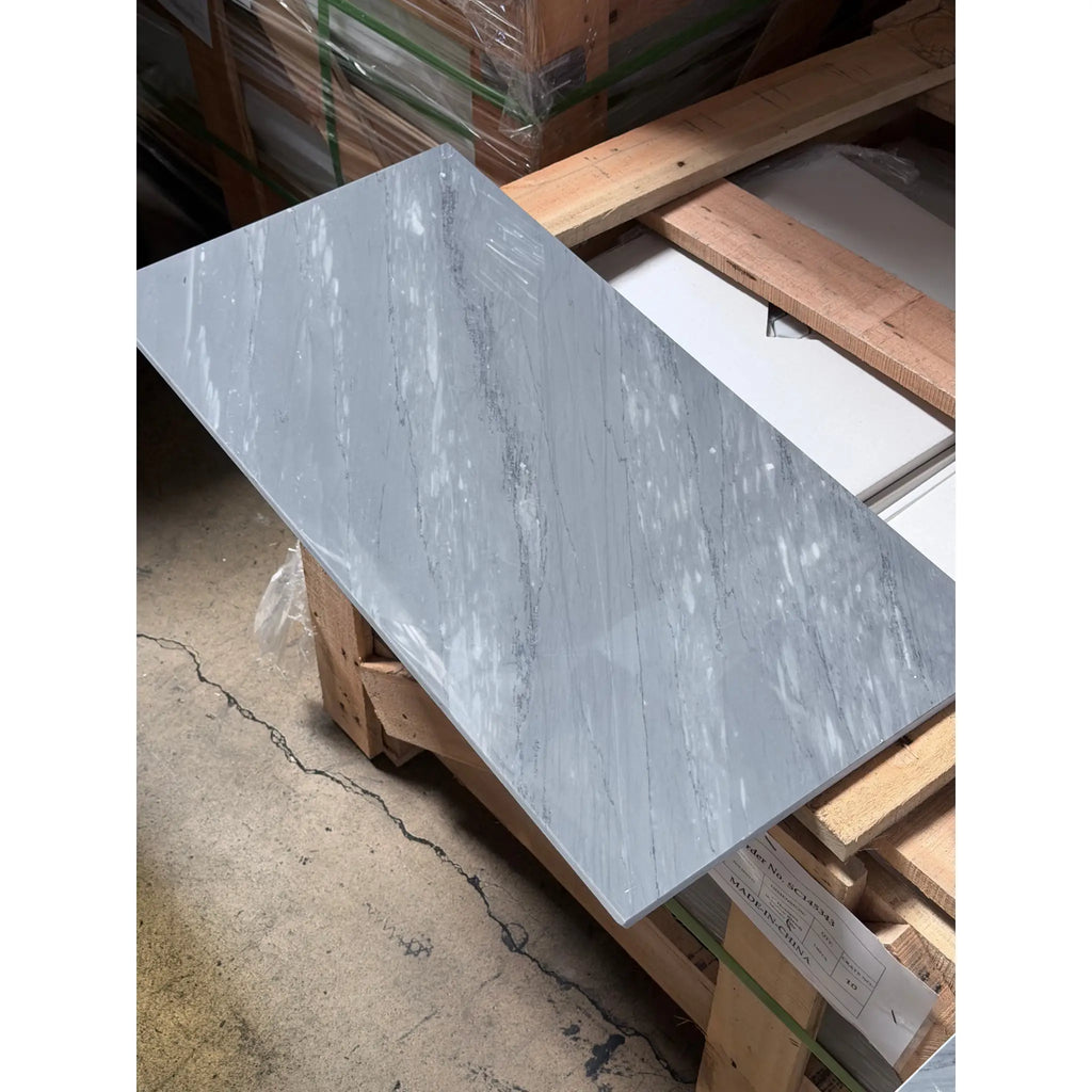 A sleek light gray Bardiglio Imperiale 12x24 marble polished tile with subtle veining and a glossy finish