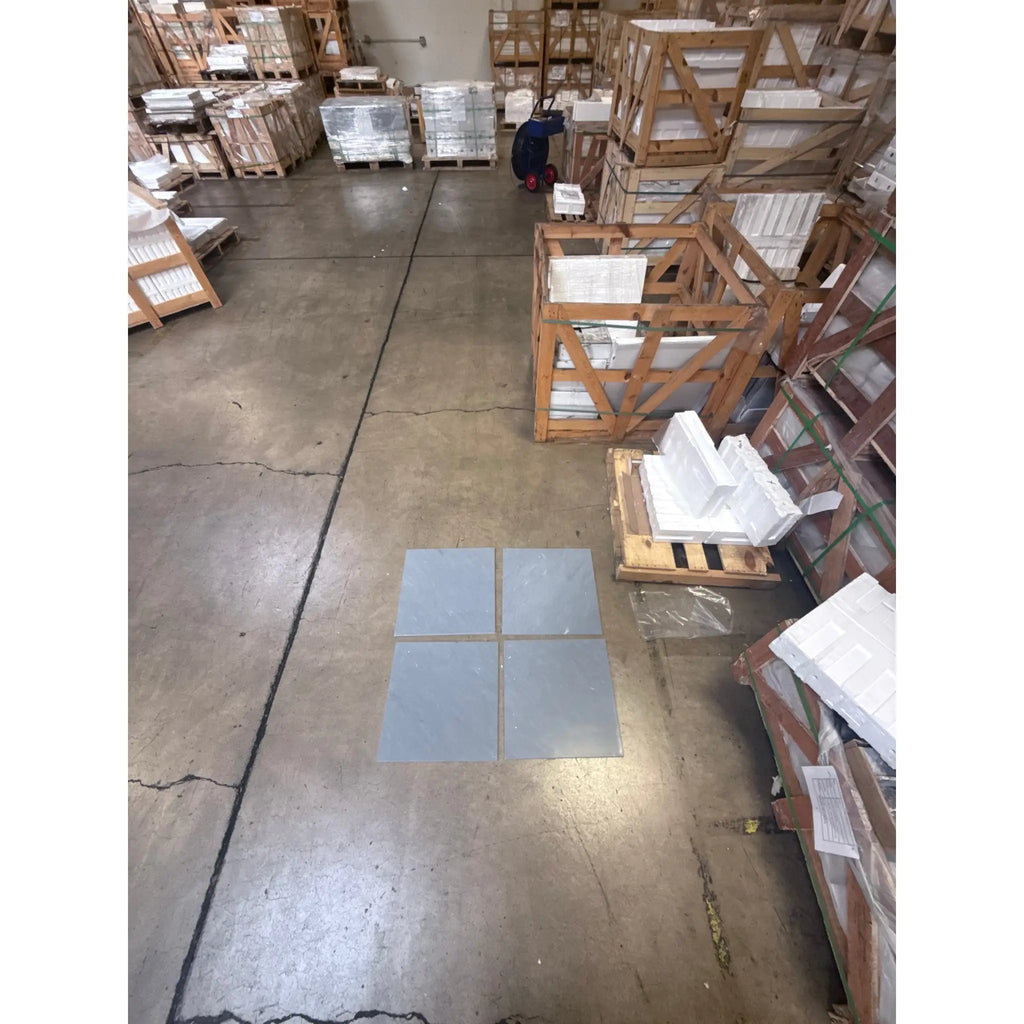 Four gray Bardiglio Imperiale 18x18 marble tiles on a polished or honed floor