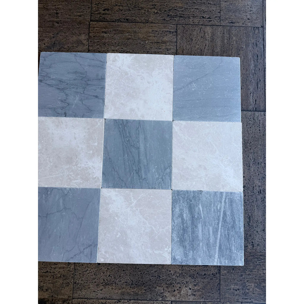 A square arrangement of bardiglio imperiale 12x12 marble tumbled tiles in alternating gray and beige with subtle veining