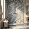 Modern chrome finished showerhead with minimalist design mounted on bardiglio nuvolato marble rain shower system