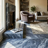 Blue and white bardiglio nuvolato marble fireplace surround with polished finish and gold-toned fire tools
