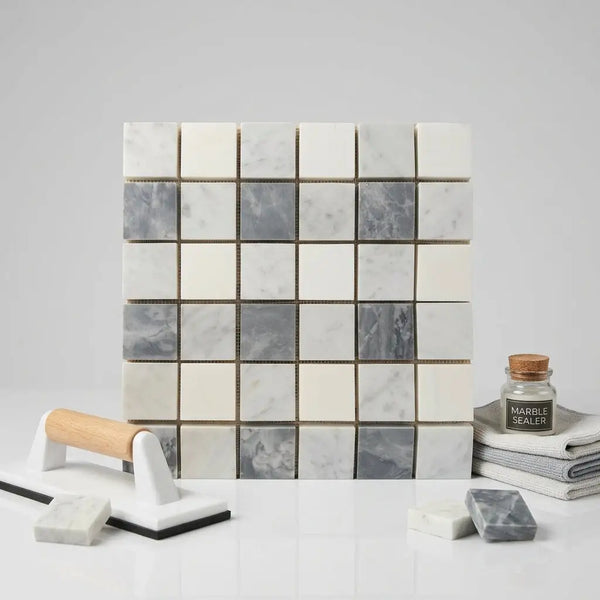 A square mosaic tile panel of bardiglio nuvolato thassos oriental white polished marble in white and gray tones
