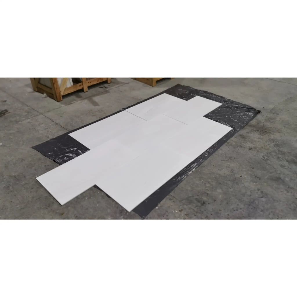 White Bianco Dolomite marble slab in flat lay on black plastic sheet