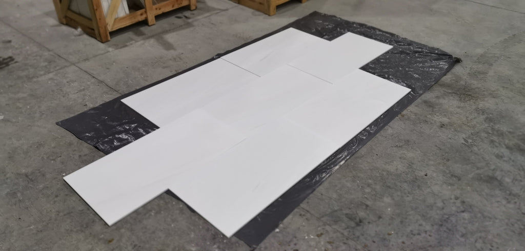 White Bianco Dolomite marble slab in flat lay on black plastic sheet