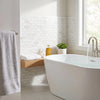 White freestanding bathtub with sleek modern design and glossy finish against bianco dolomite white dolomite 1x2 brick marble background