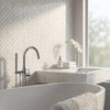 Modern chrome-finished faucet with a sleek curved spout and integrated handheld showerhead shown with white dolomite marble mosaic