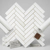 White rectangular marble tiles in bianco dolomite arranged in a polished or honed 1x4 herringbone mosaic pattern