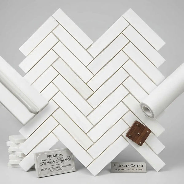 White rectangular marble tiles in bianco dolomite arranged in a polished or honed 1x4 herringbone mosaic pattern