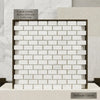 Bianco dolomite white dolomite 5/8x1 1/4 mini-brick mosaic marble tiles in a brick pattern framed by dark metal