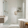 White dolomite basketweave mosaic tile shower wall with subtle dark gray square accents in polished marble finish