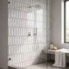 Modern chrome showerhead with a sleek circular design mounted on a bianco dolomite white dolomite picket mosaic marble wall fixture