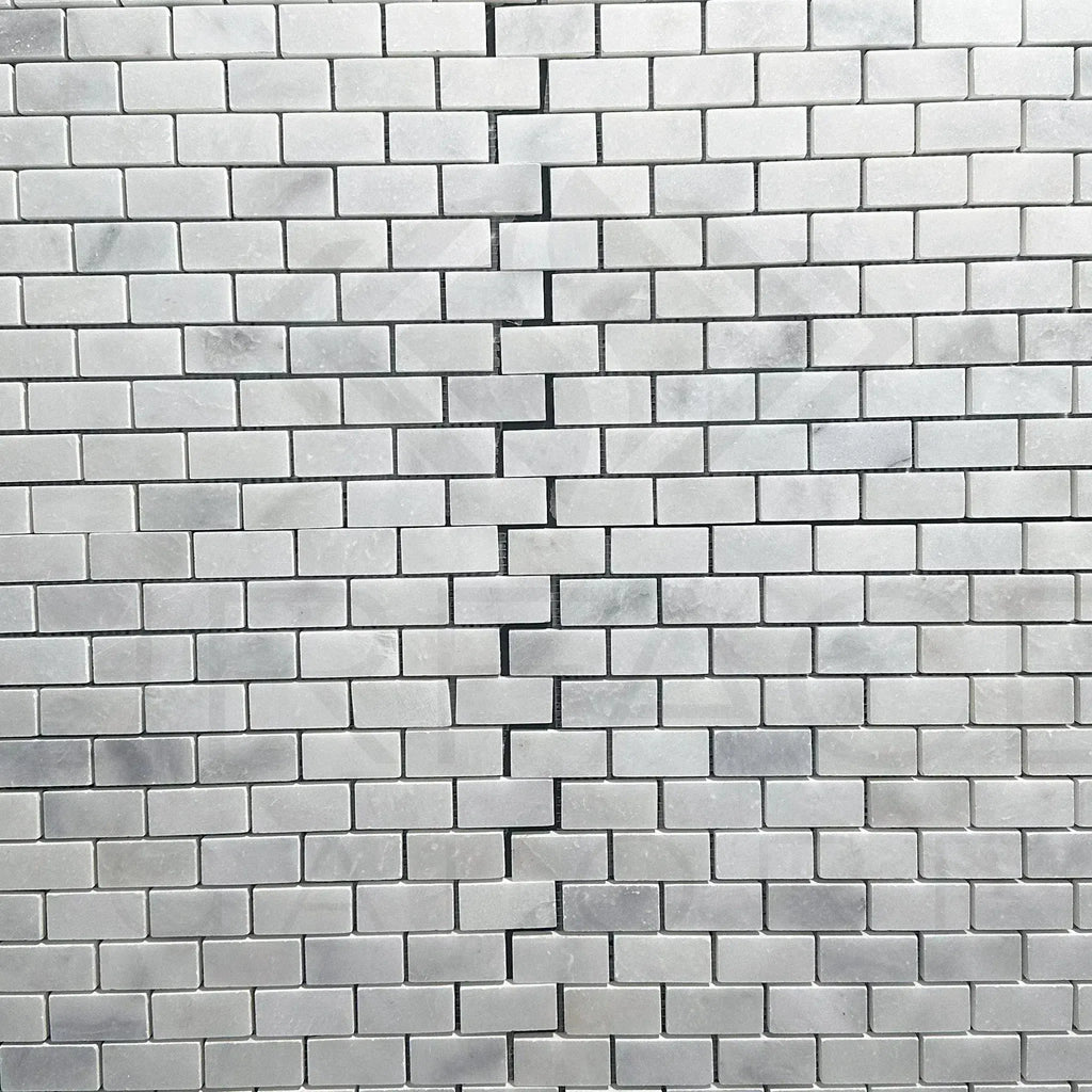 Cracked marble tile wall featuring Bianco Venatino White Marble Mosaic Tile