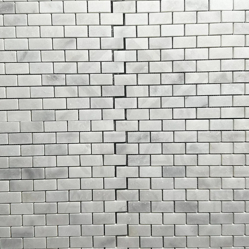 Cracked white brick wall with Bianco Venatino White Marble Mosaic Tile design