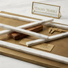 White Italian marble Calacatta Gold pencil liner rods with subtle gray veining displayed on a gold-toned tray