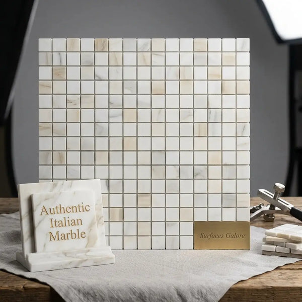 A square panel of calacatta gold 1x1 mosaic marble tile in light color with subtle veining and polished finish