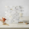 Calacatta Gold 1x2 brick split-faced mosaic marble tile in white and gray Italian marble with subtle veining in offset layout