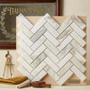 White italian calacatta gold marble tiles arranged in a polished herringbone mosaic pattern on a wooden display board
