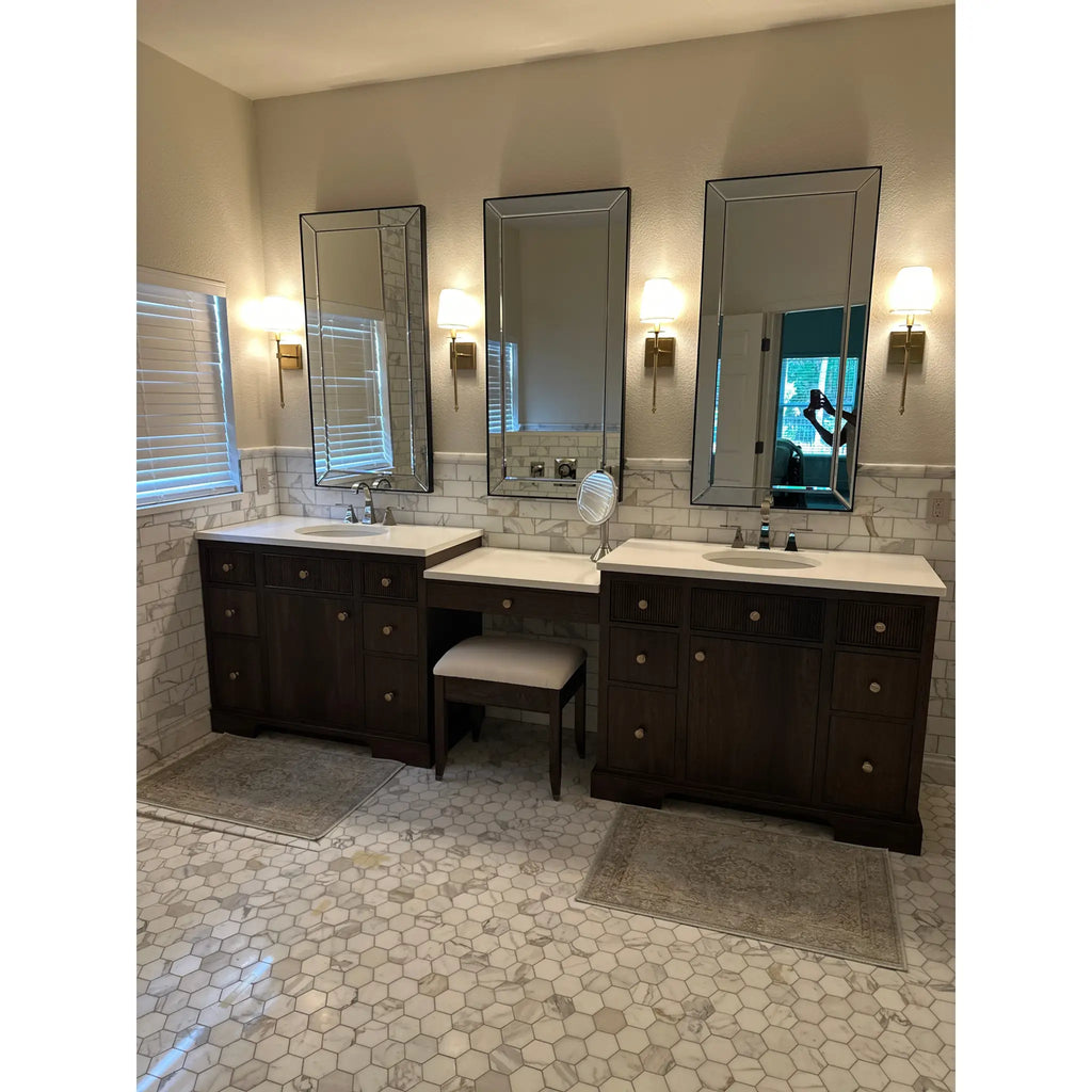 Dark wood bathroom vanity with white marble countertops and three mirrored cabinets above featuring calacatta gold 2 inch hexagon mosaic tile