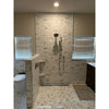 The shower features calacatta gold 2 inch hexagon mosaic marble tile polished in cream and beige on the floor