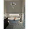 White freestanding bathtub with copper accent strip and black handle featured with calacatta gold 2 inch hexagon marble tile