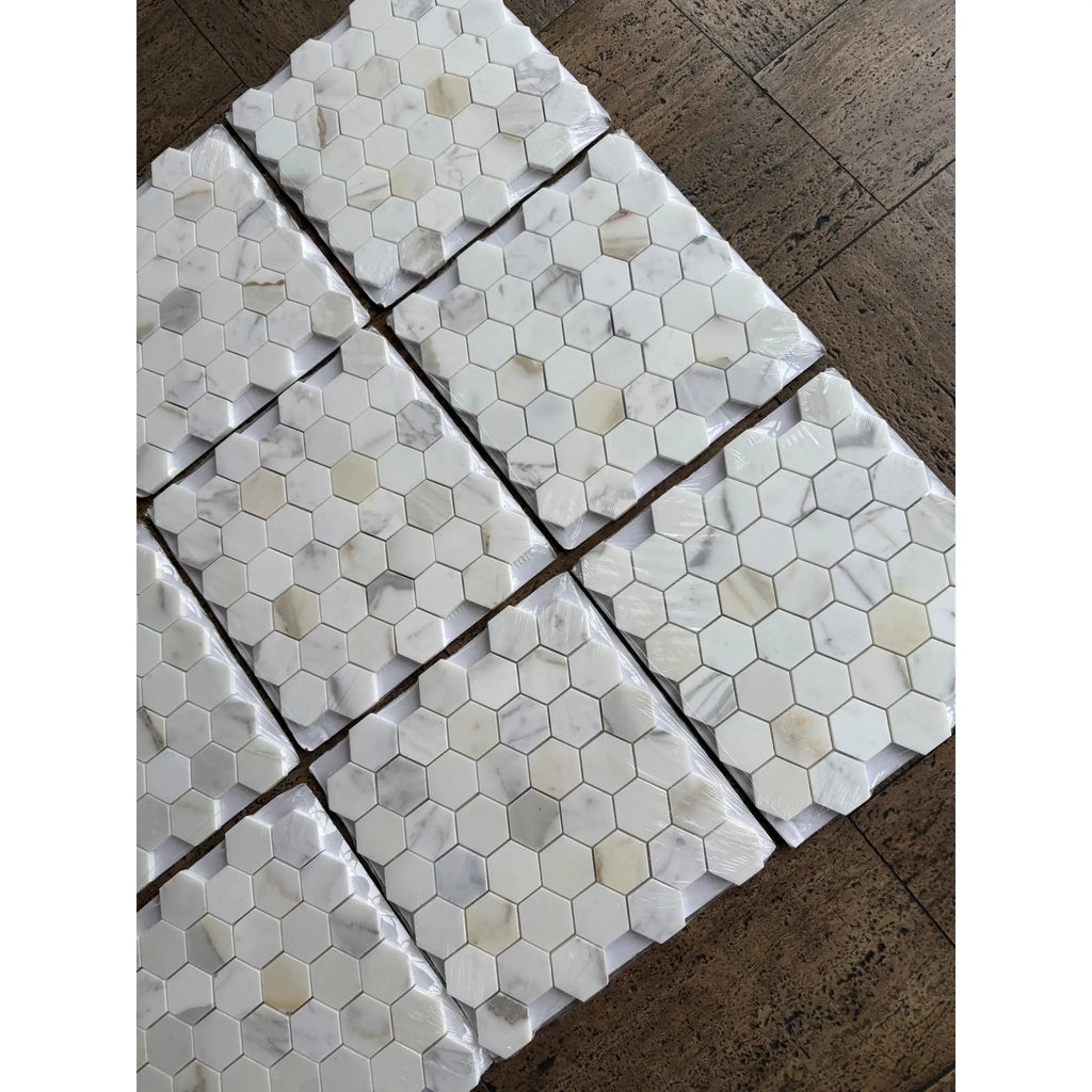 White hexagonal calacatta gold marble mosaic tile with subtle veining and polished glossy finish