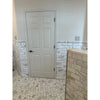White six-panel door with black handle shown alongside polished calacatta gold 2 inch hexagon mosaic marble tile