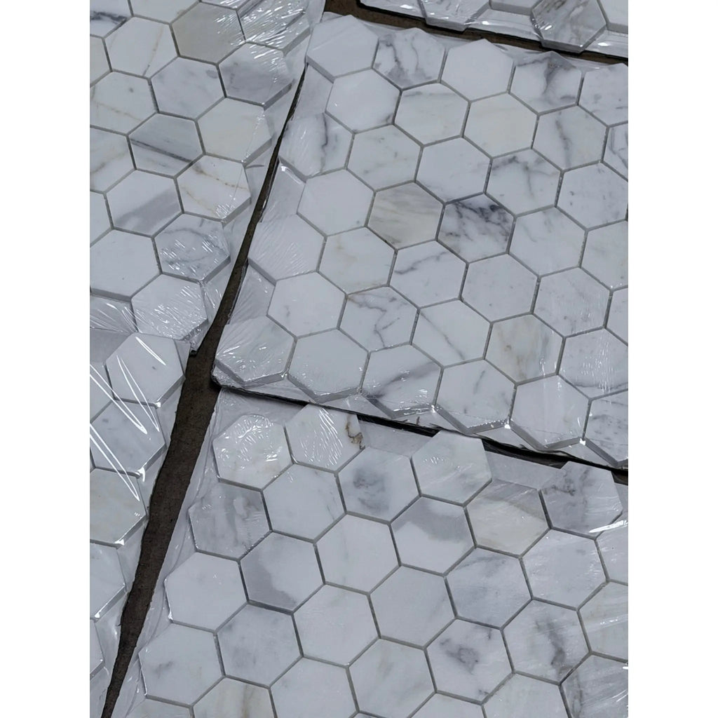 Calacatta gold 2 inch hexagon mosaic marble tile polished wrapped in clear plastic featuring white with gray veining