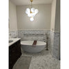 White oval freestanding bathtub with brown towel on calacatta gold 2 inch hexagon mosaic marble tile polished or honed