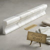 A sleek white italian marble calacatta gold 2x12 crown molding with gray veining and polished finish