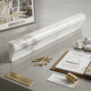 A sleek white marble calacatta gold 2x12 chair rail trim with subtle gray veining and polished finish