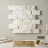 White rectangular calacatta gold 2x4 brick split-faced mosaic marble tile with subtle gold veining in a staggered pattern