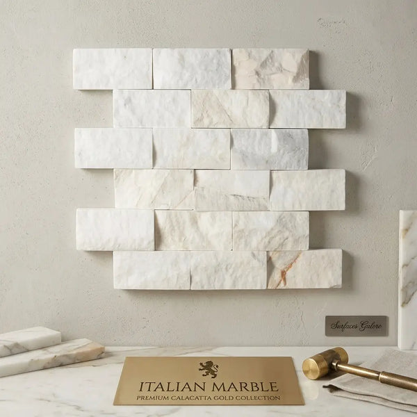 White rectangular calacatta gold 2x4 brick split-faced mosaic marble tile with subtle gold veining in a staggered pattern